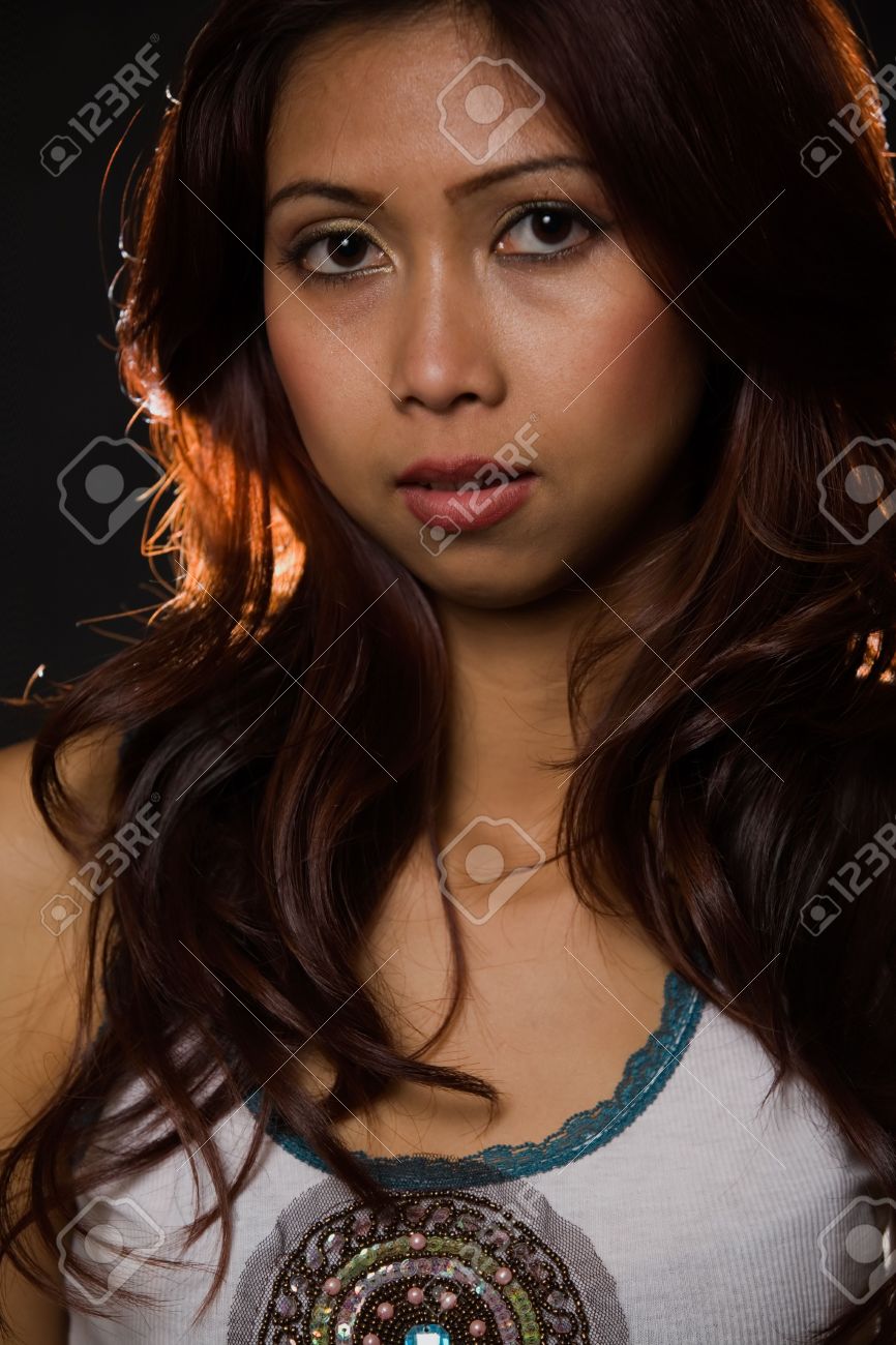 2673425-Face-of-an-attractive-Asian-woman-with-long-brunette-hair-over-dark-background-with-backlight-Stock-Photo.jpg